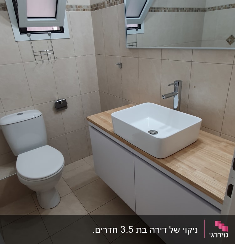 חדר אמבטיה עם כיור, מראה ושירותים נקיים